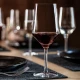 Κομψό ποτήρι κόκκινου κρασιού Zwiesel Cinco σε στρωμένο τραπέζι με σκούρα πιάτα