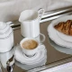 Λευκή γαλατιέρα Salt&Pepper Odette με κυματιστό σχέδιο και μαύρο περίγραμμα σε δίσκο μαζί με φλυτζάνι και ζαχαριέρα.