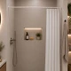 Τοποθετημένος λευκός βραχίονας μπάνιου της MRShome με λευκή κουρτίνα σε κομψό, φωτεινό μπάνιο