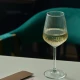 Κομψό ποτήρι λευκού κρασιού Espiel Allegra Focus 350ml με ανάγλυφες κάθετες ρίγες πάνω σε τραπέζι.