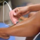 Γυναίκα χρησιμοποιεί την αποτριχωτική μηχανή Philips BRE227/00 στο πόδι της, δείχνοντας την εργονομική λαβή και το καλώδιο τροφοδοσίας.