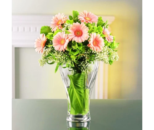 Κρυστάλλινο ανθοδοχείο Nachtmann Calypso, με μπουκέτο λουλούδια επάνω σε τραπεζάκι.