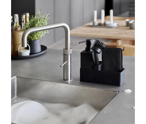 Σετ πλυσίματος πιάτων 4 τεμαχίων Zone Denmark σε μαύρο - κεραμικό δοχείο υγρού, βάση σιλικόνης, βούρτσα και πανί δίπλα στον νεροχύτη.