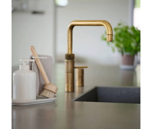 Σετ οργάνωσης νεροχύτη Zone Denmark INU off-white δίπλα στον νεροχύτη, με αντλία σαπουνιού, βούρτσα και πετσέτα