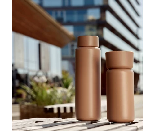 Το Singles Thermo Mug Camel σε εξωτερικό χώρο, αναδεικνύοντας τον μινιμαλιστικό σχεδιασμό του.