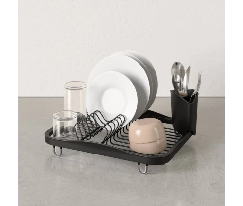 Πλάγια όψη της μαύρης πιατοθήκης Umbra Sinkin στον πάγκο με λευκά πιάτα και διάφανα ποτήρια.