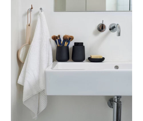 Πλήρες σετ αξεσουάρ μπάνιου Zone Denmark Nova One Black (ντισπένσερ, ποτηράκι και σαπουνοθήκη) τοποθετημένα σε λευκό νιπτήρα.