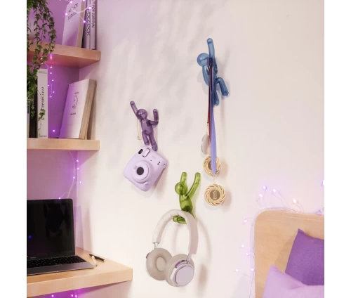 Σετ από τρεις κρεμάστρες τοίχου Umbra Buddy σε σχήμα ανθρώπινης φιγούρας που αναρριχάται σε τοίχο.