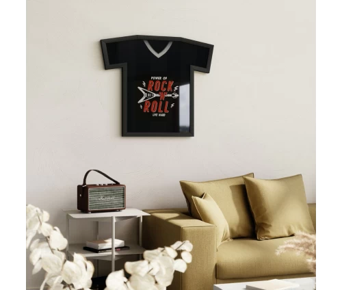 Μαύρη κορνίζα τοίχου Umbra T-Frame σε σχήμα t-shirt με τοποθετημένη μπλούζα στο εσωτερικό της, σε τοίχο πάνω από καναπέ.