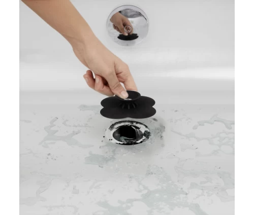 Μαύρη τάπα σιλικόνης Umbra Bloom σε σχήμα λουλουδιού, τοποθετημένη σε σιφόνι μπάνιου.