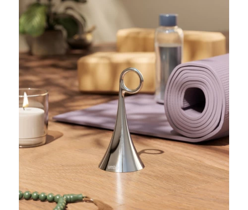 Επιτραπέζιο κουδούνι Umbra Isa Bell σε ασημί χρώμιο, σε τραπεζάκι.