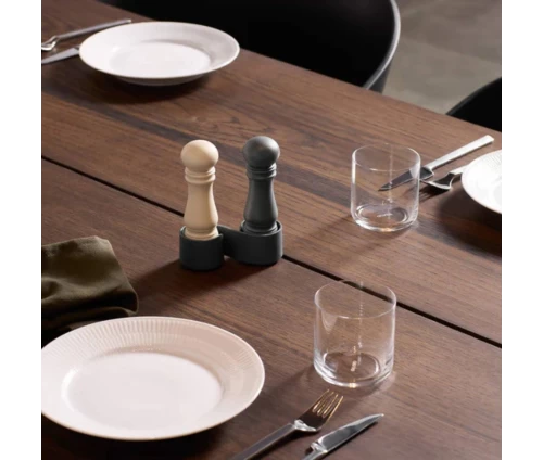 Μικρό σετ μύλων αλατιού και πιπεριού CrushGrind με πρακτική βάση μεταφοράς. Σε χρώματα σκούρο μπλε (blueberry) και κρεμ (garlic), τοποθετημένοι σε τραπέζι.