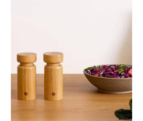 Σετ 2 ξύλινων μύλων αλατιού και πιπεριού Helsinki της CrushGrind, τοποθετημένοι σε τραπέζι σε λιτή σύγχρονη κουζίνα.