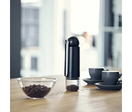 Χειροκίνητος μύλος άλεσης κόκκων καφέ Colombia της CrushGrind, με αποσπώμενη λαβή και slim, lifestyle φωτοφραφία μαζί με φλυτζανάκια και κόκκους καφέ.