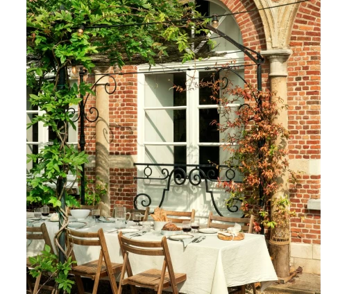 Υφασμάτινο τραπεζομάντηλο Finesse WOW σε ιβουάρ απόχρωση (Essence Ivory), στρωμένο κομψά σε τραπεζαρία σε εξωτερικό χώρο.