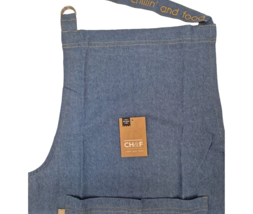 Κοντινό πλάνο της τζιν ποδιάς Finesse CHEF που αναδεικνύει τον μεταλλικό κρίκο και το μότο 