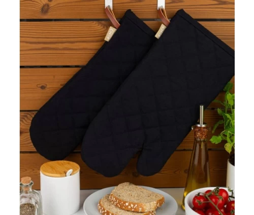 Μαύρα γάντια Finesse CHEF BBQ κρεμασμένα πρακτικά σε ξύλινο τοίχο στην κουζίνα.