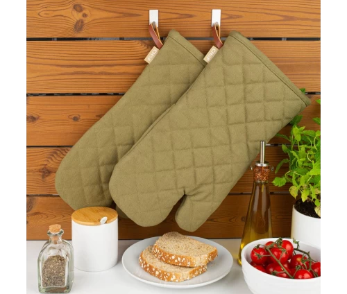 Λαδί γάντια κουζίνας Finesse CHEF BBQ κρεμασμένα σε ξύλινο τοίχο, αναδεικνύοντας το μεγάλο τους μήκος (35 εκ.) για προστασία.