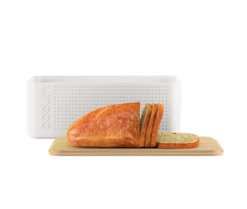 Το αναστρέψιμο καπάκι της λευκής ψωμιέρας Bodum Bistro χρησιμοποιείται ως ξύλο κοπής.