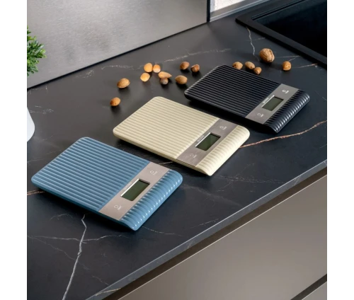 Τρεις ψηφιακές ζυγαριές κουζίνας Guzzini Sous Chef σε navy blue, μπεζ και μαύρο χρώμα πάνω σε μοντέρνο πάγκο.